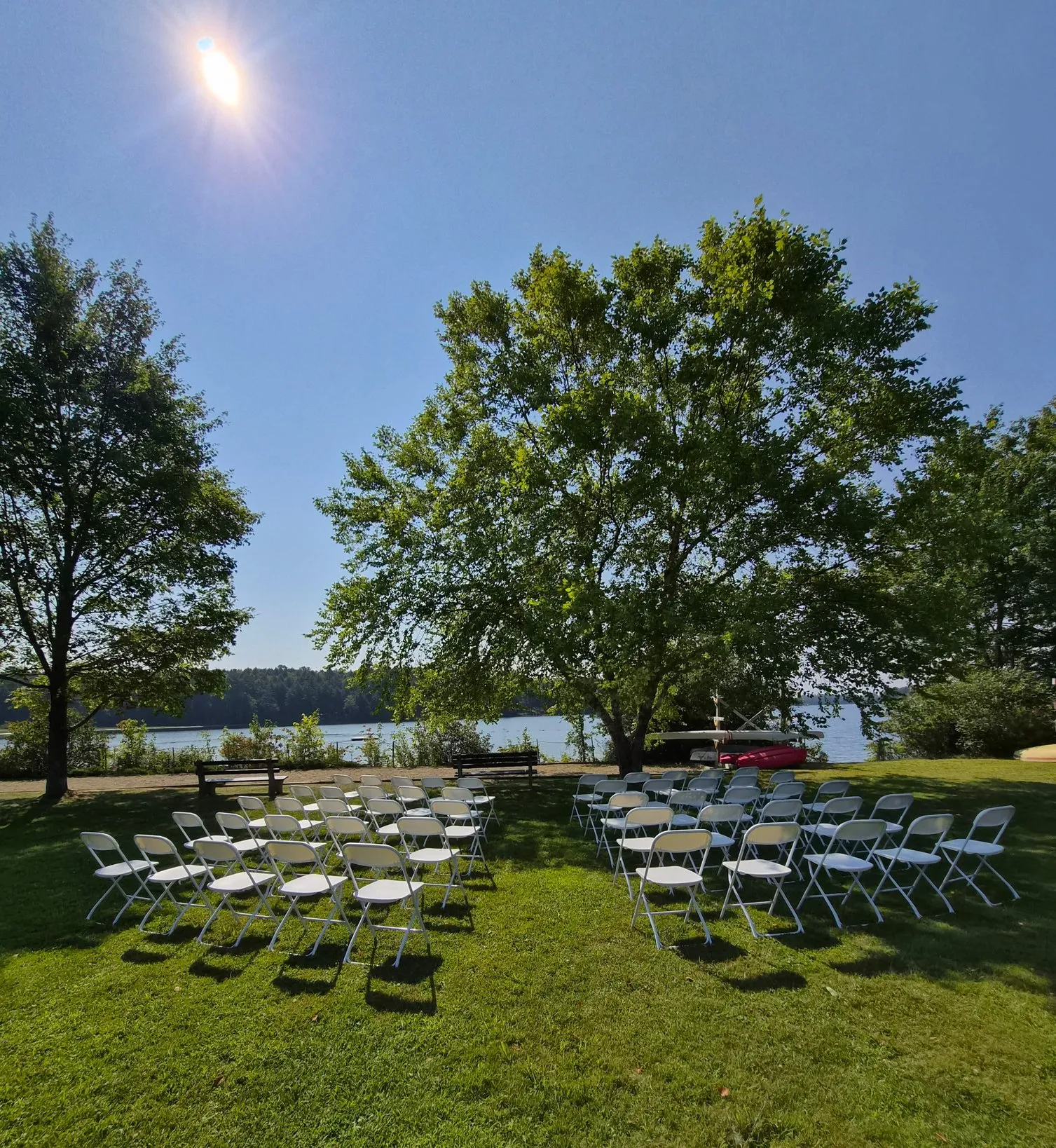 Wedding Ceremony with 50 white premium folding chairs facing the lake in Readfield, Maine