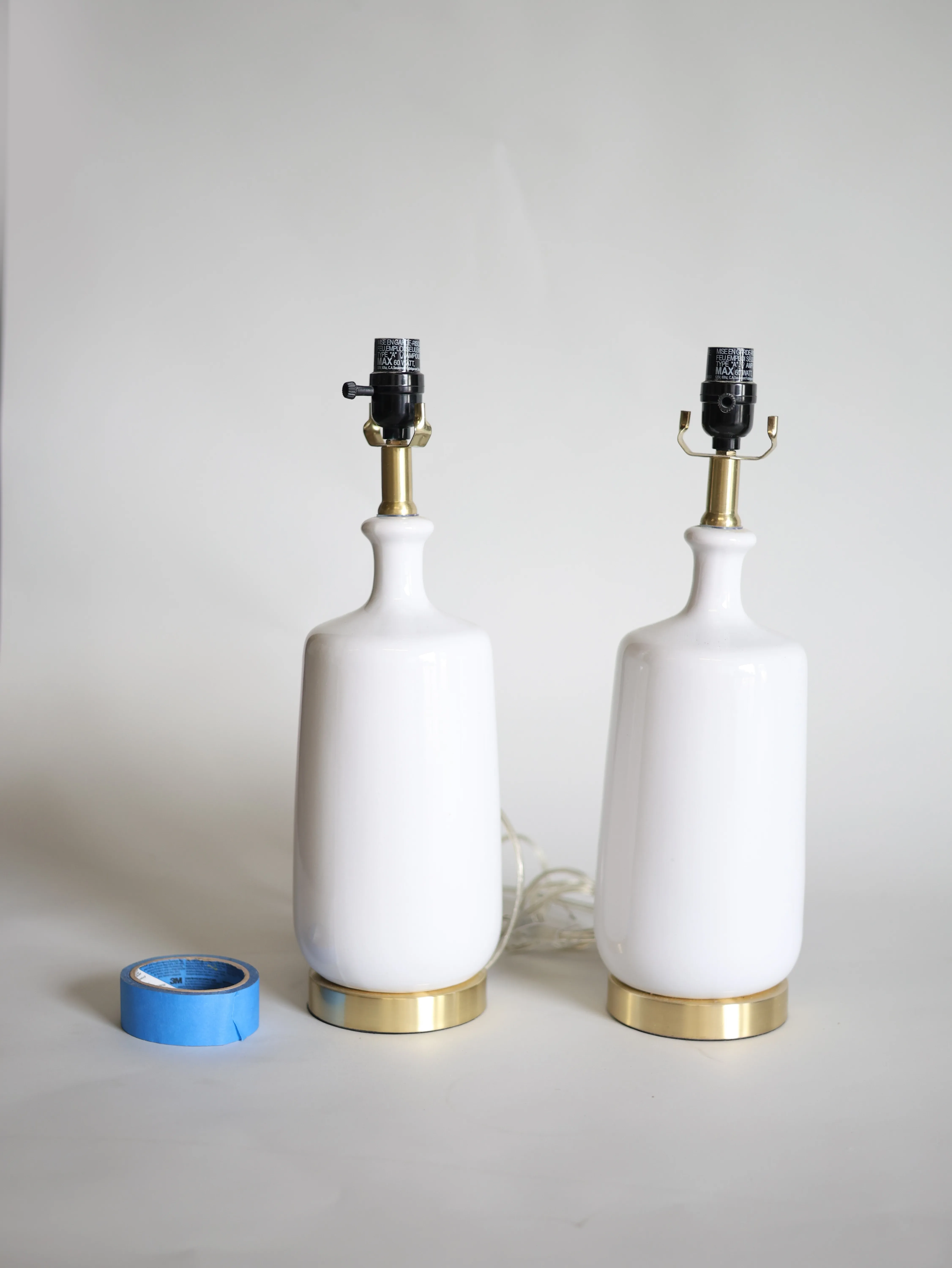 Pair of white table lamp bases with golden base